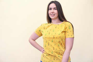 Obraz premium Beautiful plus size curly young brunette woman posing on yellow