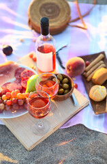 Picnic outdoor with rose wine fruits meat and cheese