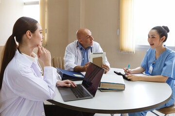 Obraz premium team doctor, nurse and internship doctor talking and meeting about surgery treatment patient’s case while sitting in the room office in hospital. healthcare and medical concept.