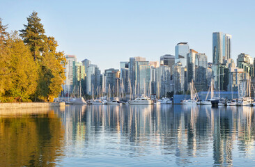 The Seawall and the skyline of Vancouver as seen from Stanley Park during a golden hour sunset in...