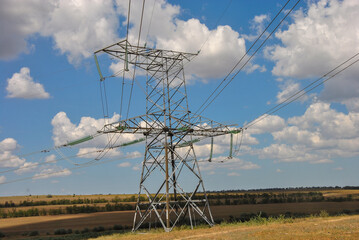 high voltage power line. high voltage line tower in the field and sky with clouds. 