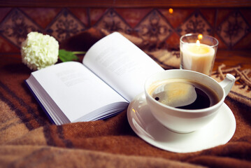 Coffee, book, plaid and candle at home