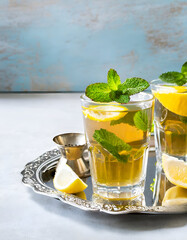 Moroccan mint tea in glasses with cough sugar on silver tray, text space.