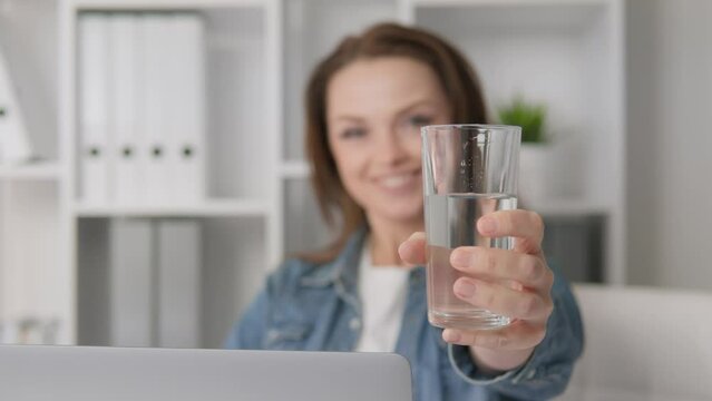 Positive and emotionally minded woman at home maintains her health through daily practice drinking water. Simple step towards happiness and well-being. Brings glass water to chamber offers to take it