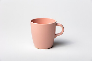 Mockup of a tea cup or coffee mug, pink color, isolated, on a plain background, ready to overlay...