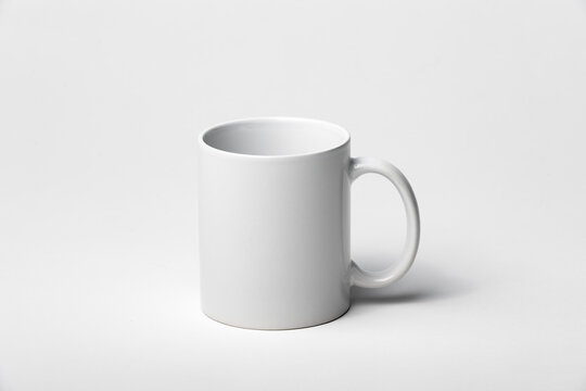 Mockup of a coffee cup or mug, white, isolated, on a plain background, ready to overlay designs or logos for merchandising