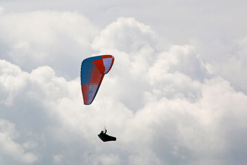 Paraglider flying in a cloudy sky