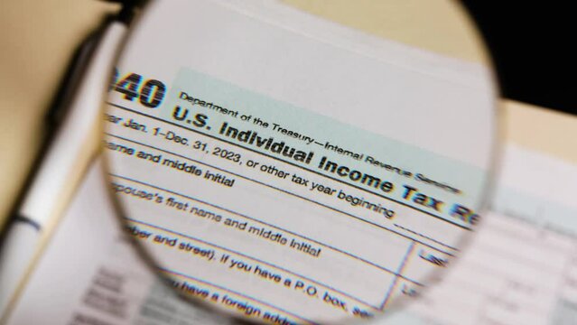 Magnifying glass looking at 1040 tax form