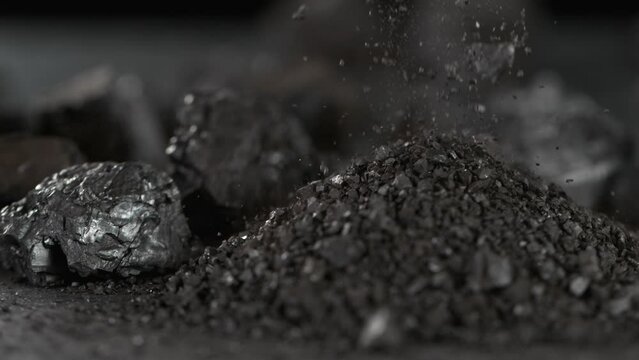 Super Slow Motion Shot of Spilling Crushed Coal Isolated On Black Background at 1000 fps.