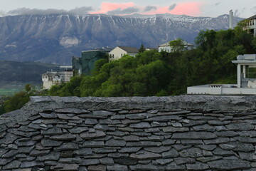 View over the flat dressed stone covered roof of an Ottoman era house to the snowcapped Lunxheri...