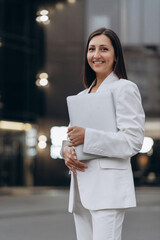 Portrait of a smiling business woman in a white suit. Close up.