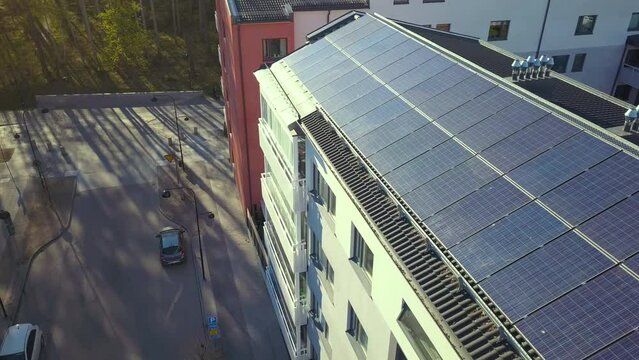 Aerial view of Swedish apartment building covered with solar photovoltaic panels in Linkoping residential area. Renewable electricity development