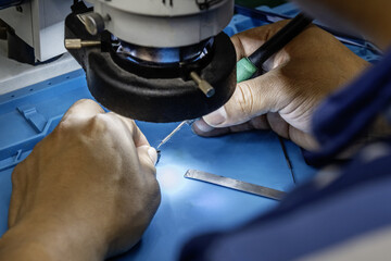 Image of a repair technician in an electronics store working at his station with an electron...