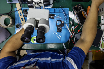 Top view image of a repair technician in an electronics store working