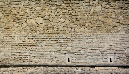 Very old brick stone wall of castle or fortress of 18th century. Full frame wall with obsolete dirty and cracked bricks close up