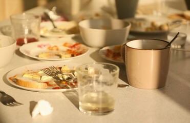 Empty dirty plates with spoons and forks on the table after meal. Banquet ending concept. Unwashed dishes ready to cleaning
