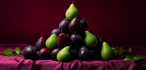 An artistic pyramid of black Doris plums, green gage plums, and red plums on a pastel magenta cloth