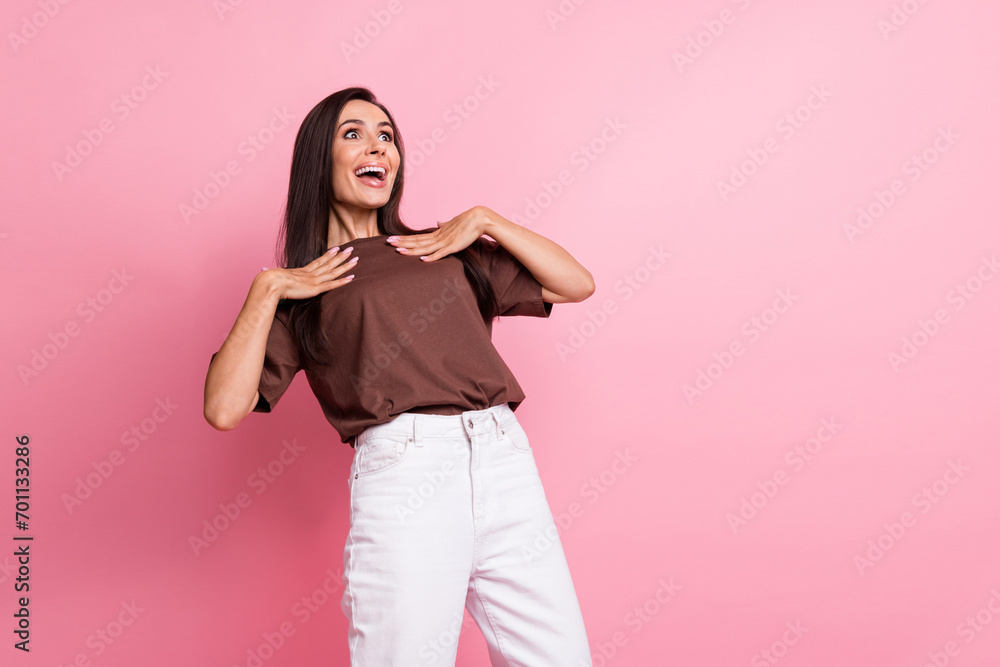 Wall mural Portrait of nice astonished person arms touch chest look empty space ad isolated on pink color background