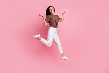 Fototapeta na wymiar Full body length photo of carefree girl raised palms up having fun toothy smiling and feel freedom isolated on pink color background