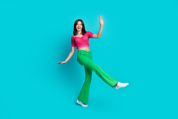 Fototapeta na wymiar Full length photo of friendly optimistic woman dressed knitwear top green retro pants dancing have fun isolated on blue color background