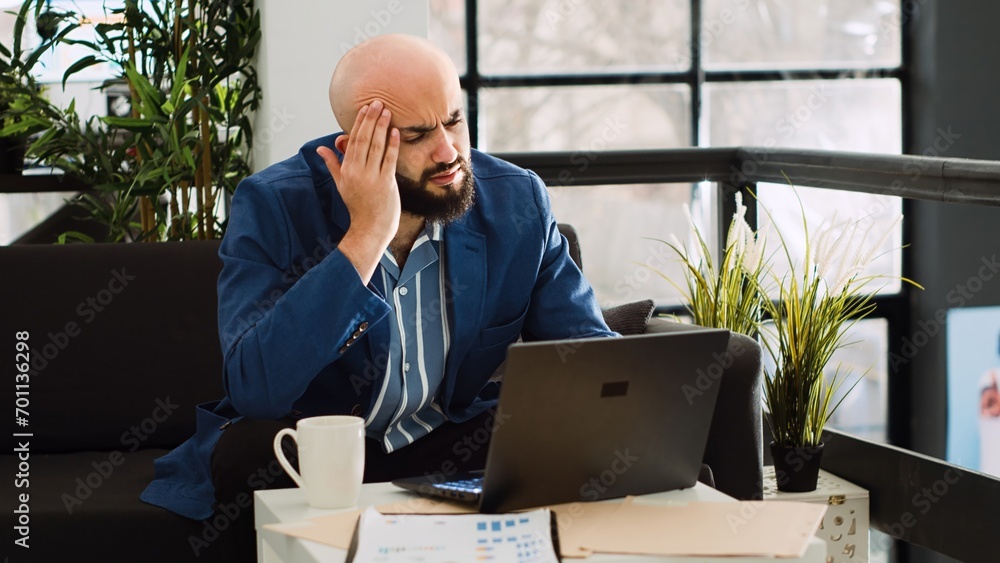 Poster analyst dealing with headache at work, trying on examine annual data strategy but feeling unwell. si