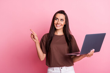 Photo of woman brunette hair recommend shopping proposition directing finger banner mockup with laptop isolated on pink color background