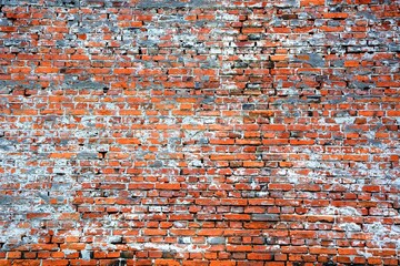 Old red brick wall with fallen plaster