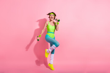 Full length portrait of energetic astonished person arms hold dumbbells look empty space isolated on pink color background