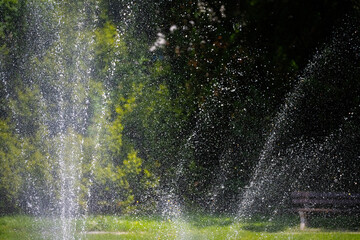 Fountain water drops with mature trees in the background