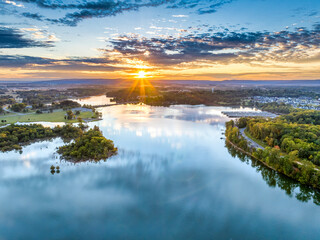 Aerial view of a beautiful morning sunrise sky and water reflection over the mountain and lake,...