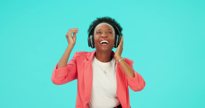 Music, dancing and black woman with headphones to listen in studio isolated on a blue background mockup space. Radio, streaming and happy person hearing podcast, sound or audio for moving with energy
