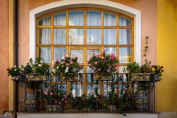 Fototapeta na wymiar Decorated balcony with blooming potted flowers in Taormina in Sicily, Italy