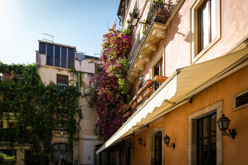 Fototapeta na wymiar View of charming city of Taormina with buildings and potted plants
