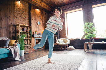Full size photo of overjoyed pretty girl have good mood enjoy dancing barefoot carpet apartment inside