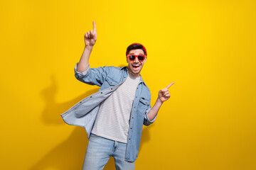 Photo of cheerful good mood man dressed jeans shirt dark spectacles pointing fingers empty space...