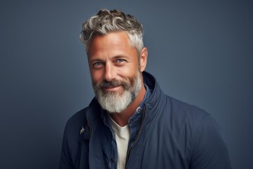 Portrait of a handsome middle-aged man with grey hair and beard.