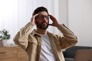 Tired man suffering from headache in office