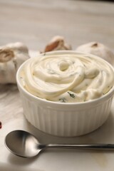 Tasty sauce with garlic and spoon on table, closeup