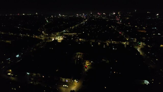 Aerial View of Illuminated City During Dark Night and Live Fireworks on New Year's Night over Luton, England UK. January 1st, 2024