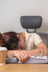 Fototapeta na wymiar Stressed Asian woman having Tired and Sleepy while working, female businesswoman having headache at office, Exhausted woman with documents folder stack at home late night. Overworked and Overtime