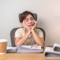 Fototapeta na wymiar Stressed Asian woman having Tired and Sleepy while working, female businesswoman having headache at office, Exhausted woman with documents folder stack at home late night. Overworked and Overtime