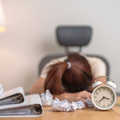 Stressed woman having Tired and Sleepy while working, female businesswoman having headache at office, Exhausted woman with documents folder stack and clock at home late night. Overworked and Overtime