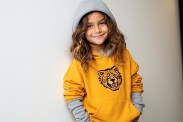 Portrait of a cute little girl in a yellow hoodie and gray cap