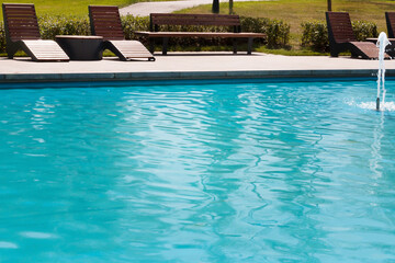 wooden chair and table place nearby the pool.