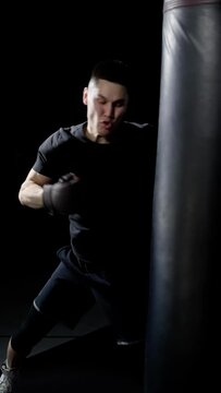 Slow motion footage of boxer's punches. Close-up of a young athlete who hits a sports projectile. Slow motion. Vertical video for your phone.