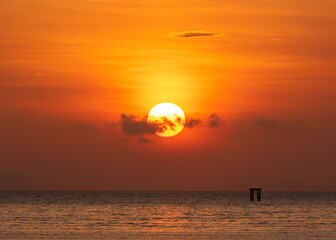 Beautiful sunrise over the sea at Saphanhin public beach, Phuket, Thailand.