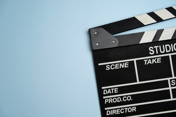 Fototapeta na wymiar movie clapper on blue table background ; film, cinema and video photography concept