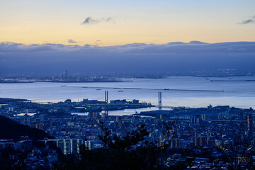 夜明け前の神戸、大阪湾を隔てて大阪の市街地をのぞむ