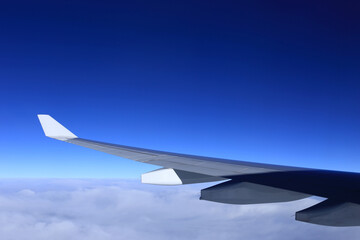 airplane wing, view from aircraft window with beautiful blue sky, flying and traveling