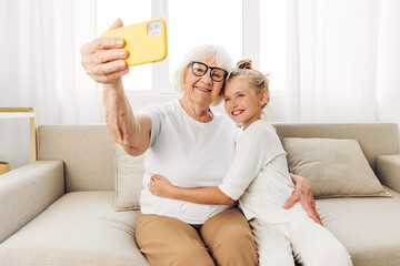 Education hugging togetherness phone sofa smiling child bonding selfie family granddaughter...